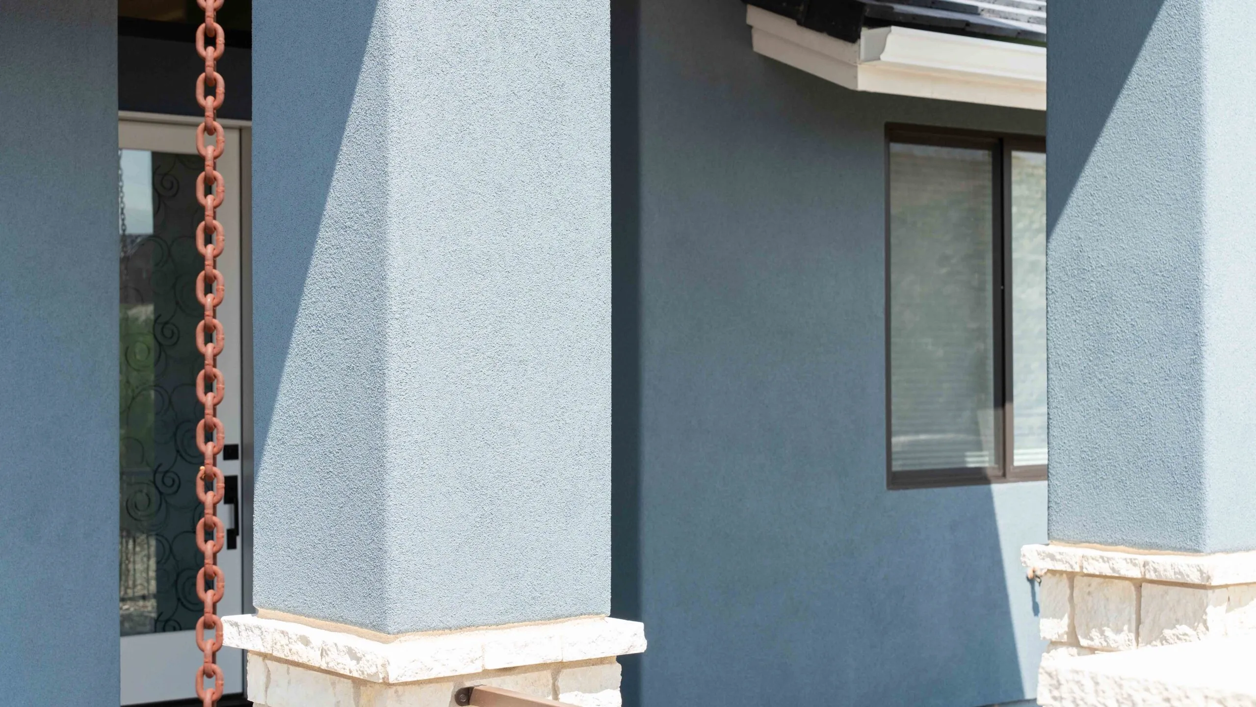 Blue stucco columns with rain chain detail