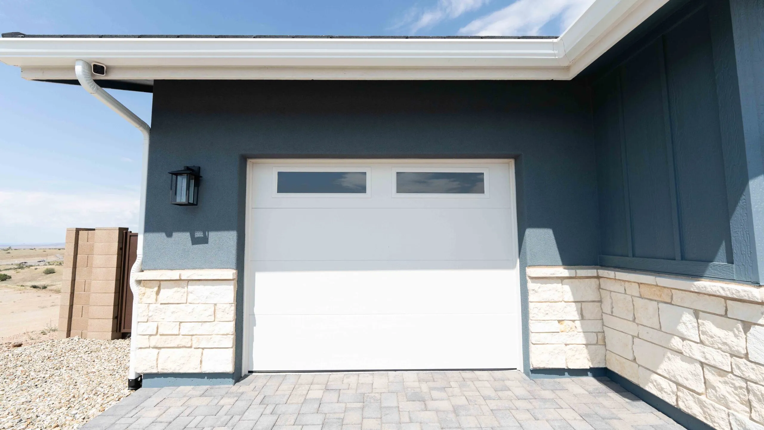 Blue stucco garage with stone wainscot